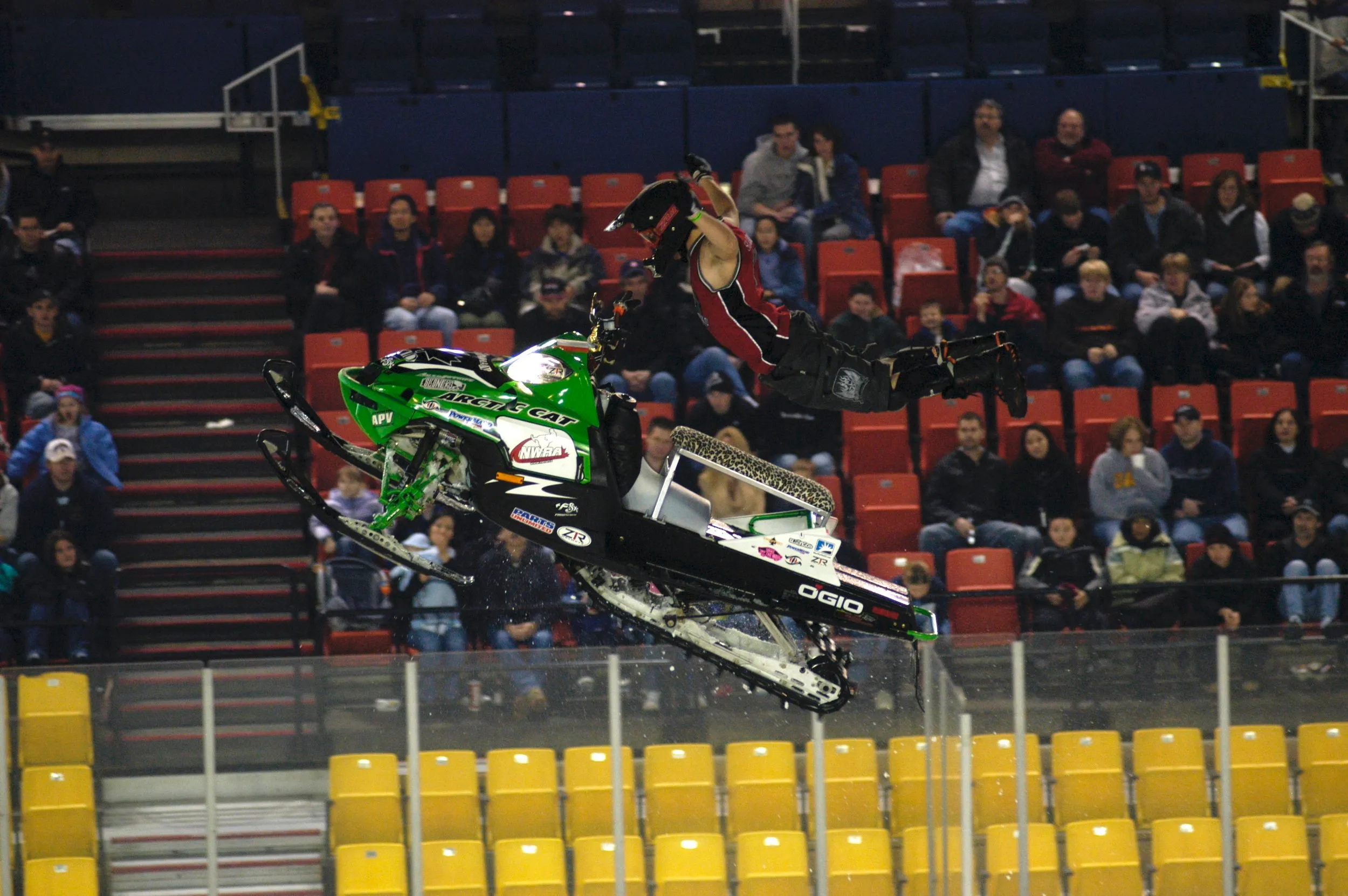 Lee Stuart doing a Superman extension on an Arctic Cat snowmobile in an arena