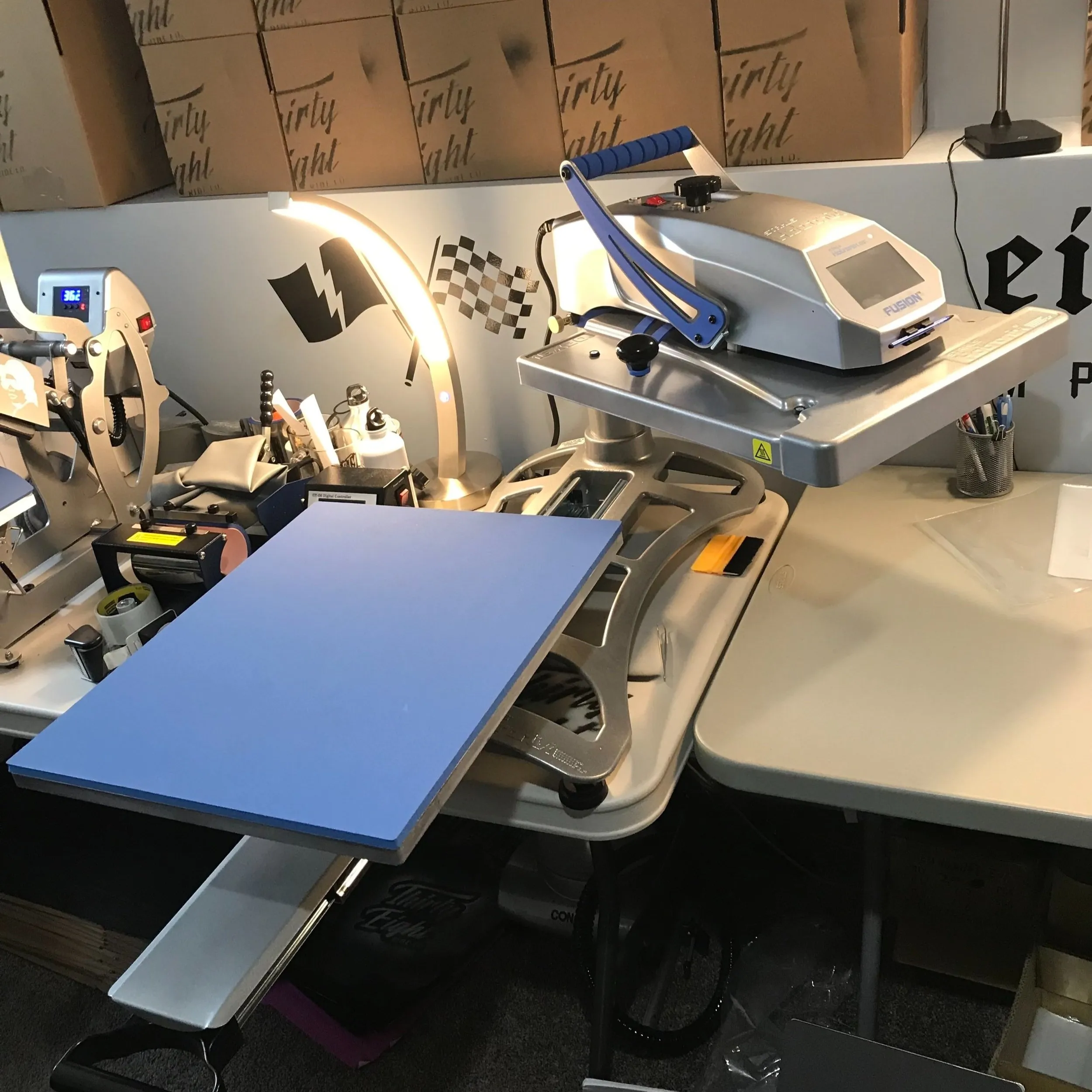 Early home heat-press setup with Thirty Eight shipping boxes
