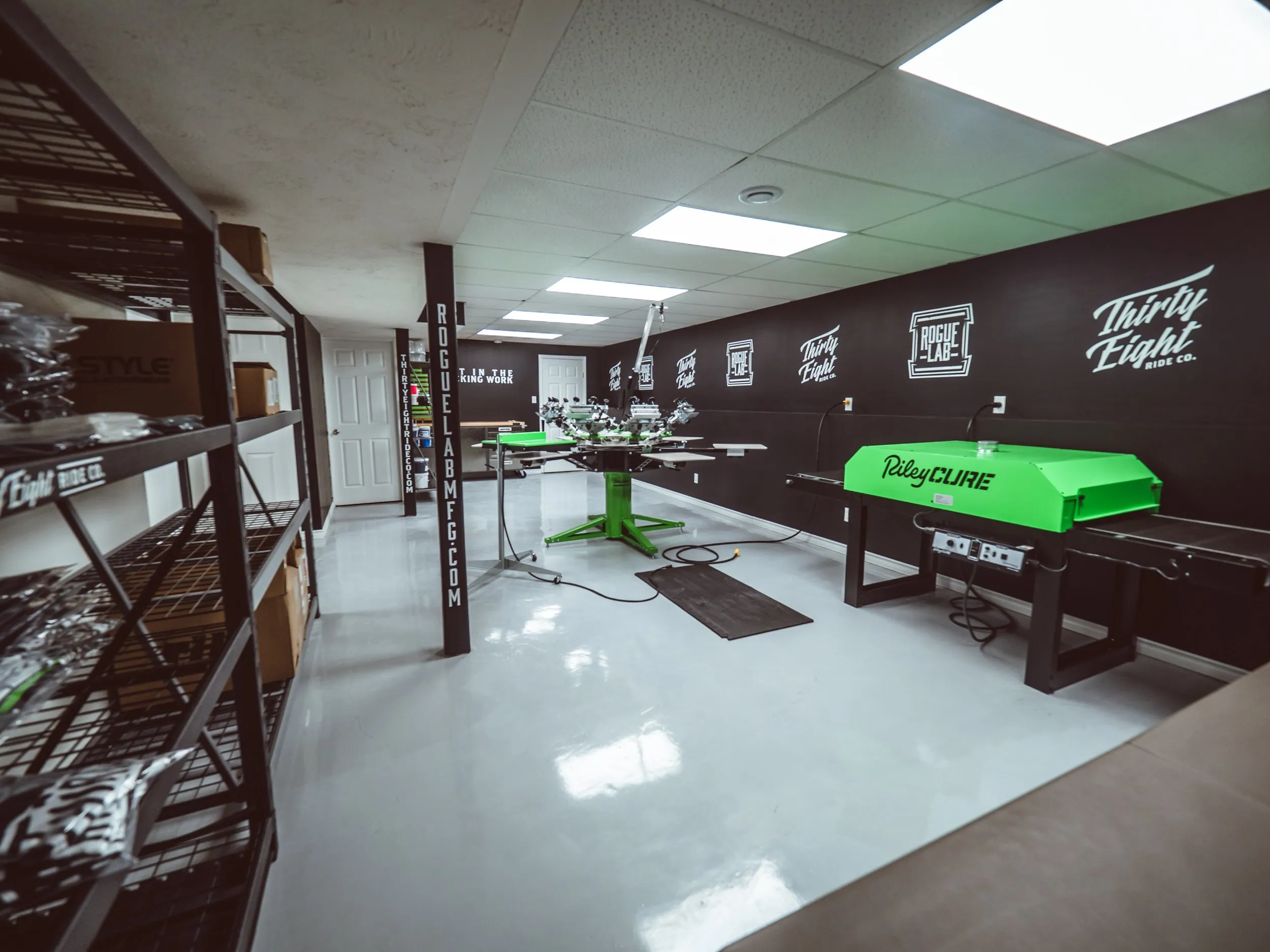 Basement screen-printing shop with a manual press and RileyCure dryer
