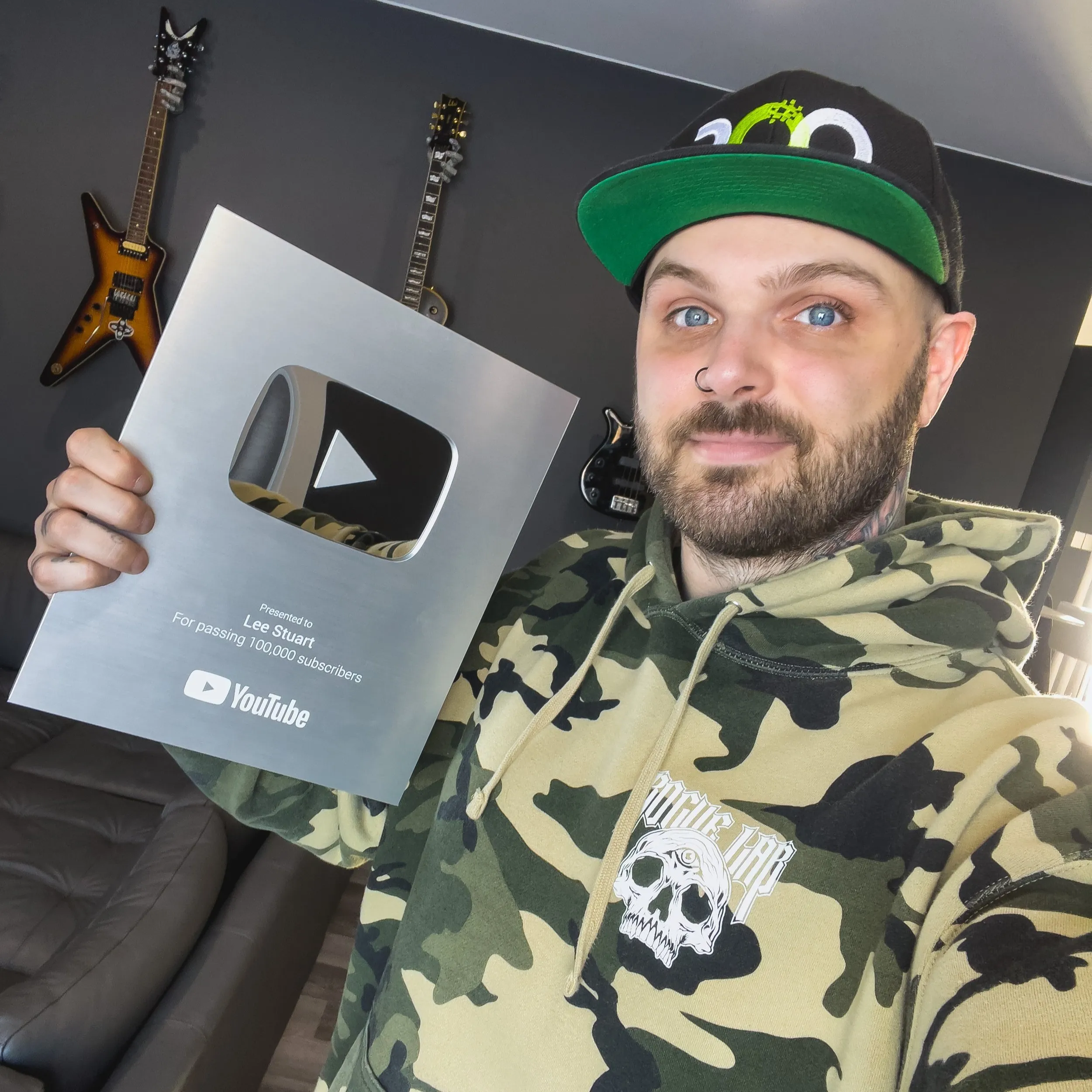 Lee Stuart holding a YouTube Silver Creator Award for 100,000 subscribers