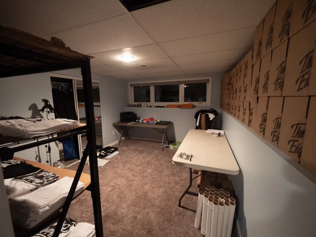 Early Thirty Eight inventory room with shirt racks and stacked shipping boxes