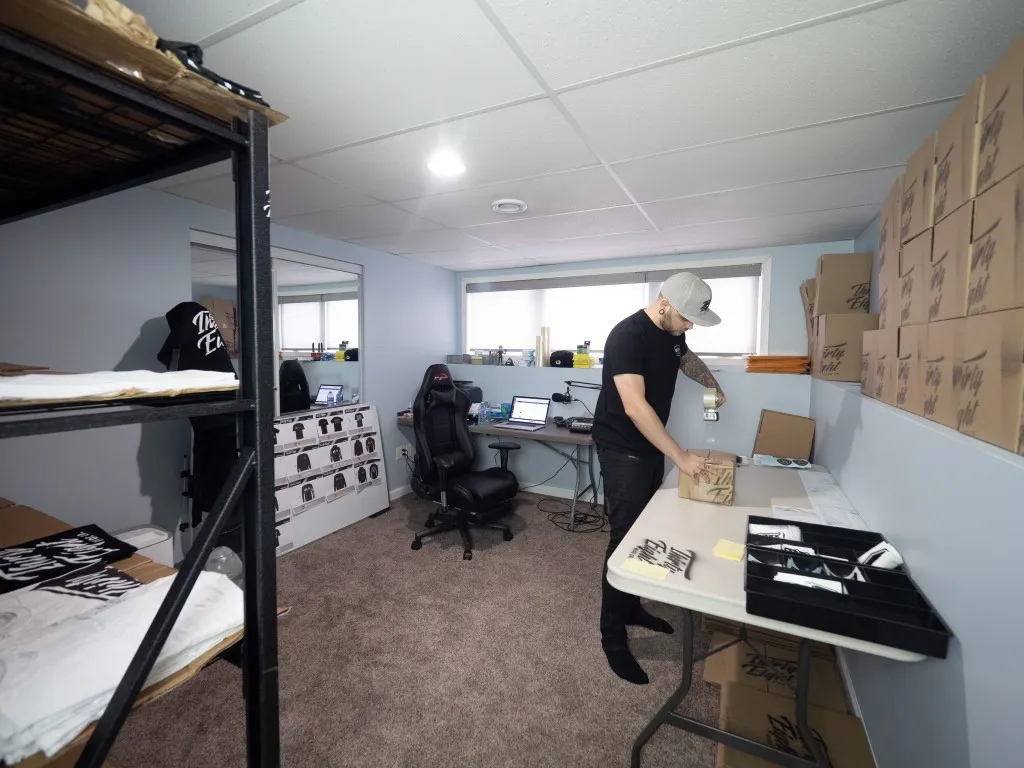 Lee Stuart packing Thirty Eight orders at a folding table in the basement