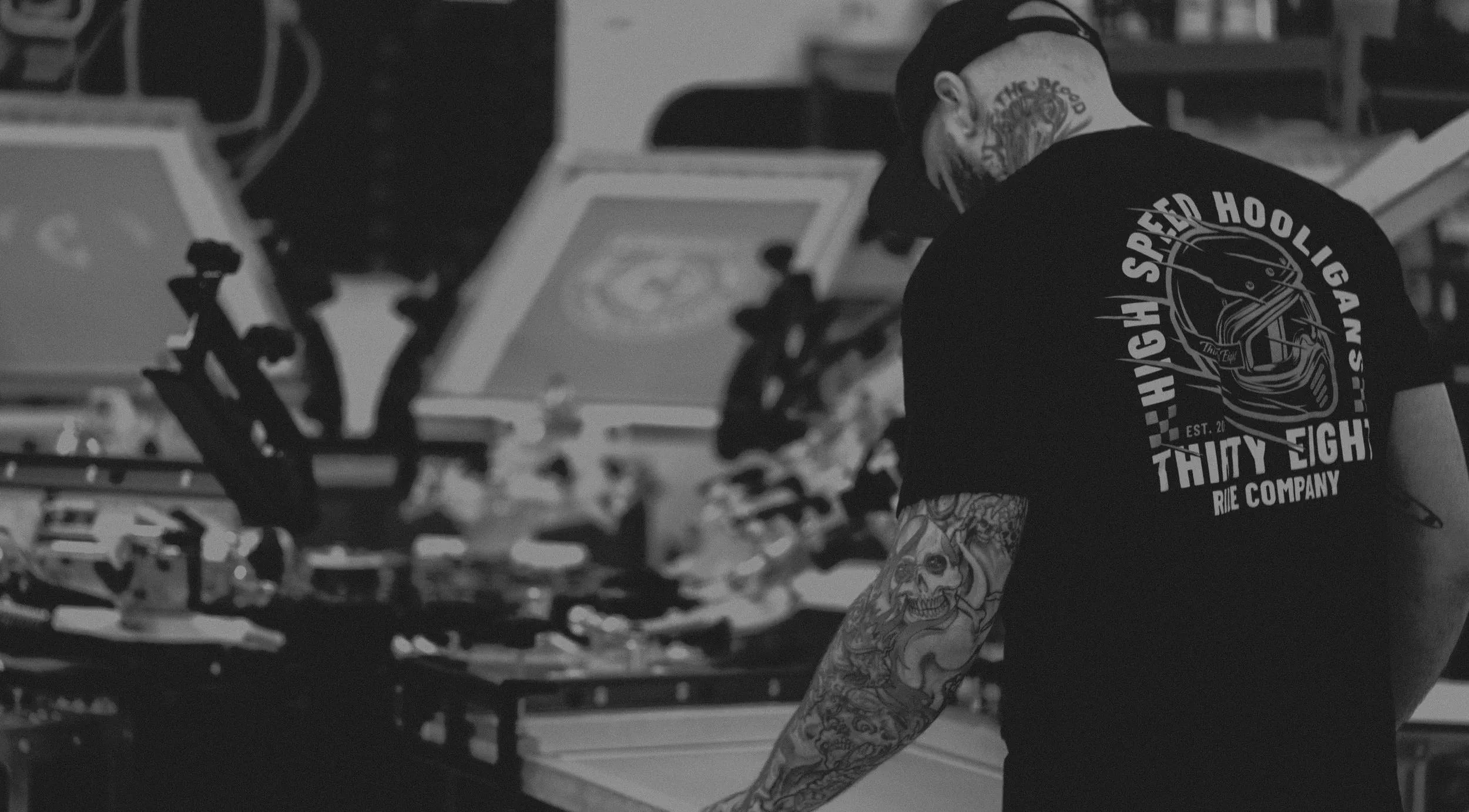 Lee Stuart working at the screen printing presses, back to the camera