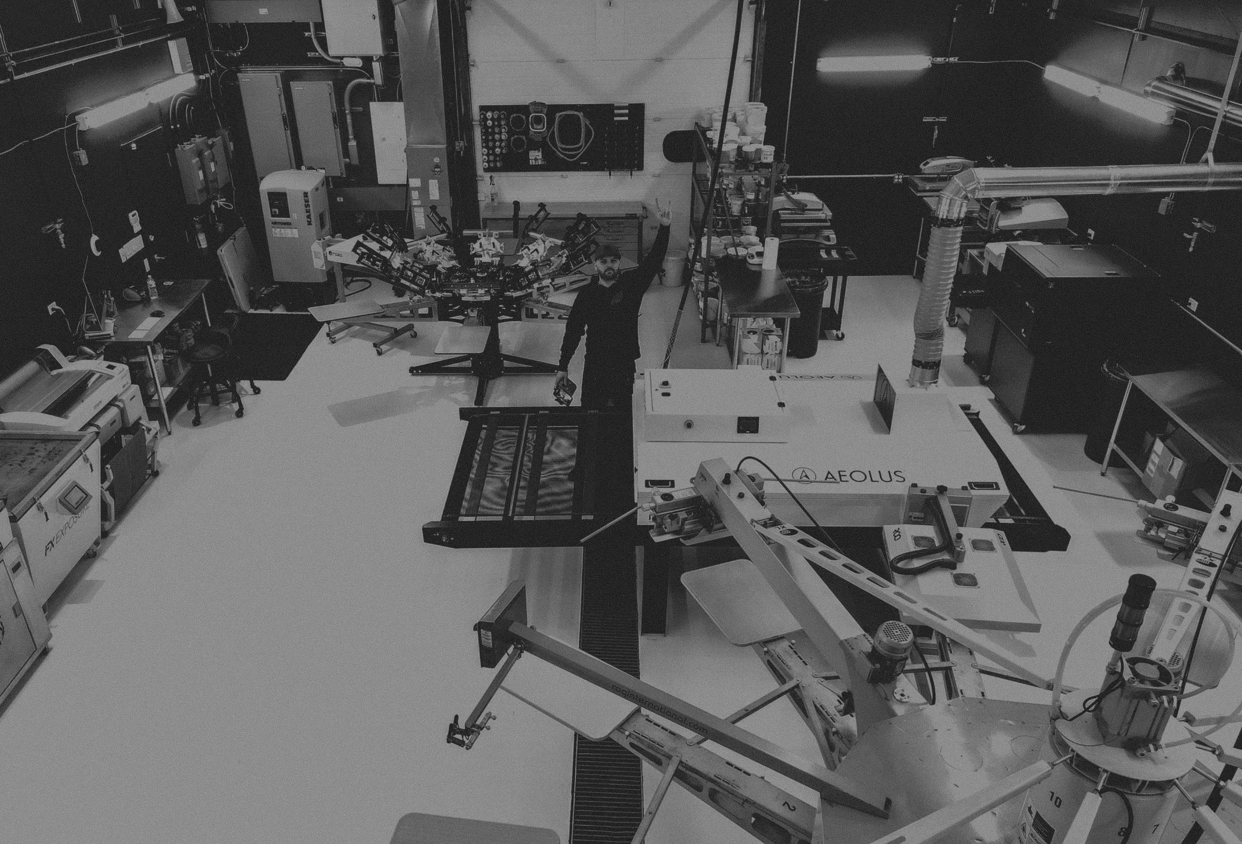Overhead view of the Rogue Lab production floor, Lee standing among the machines